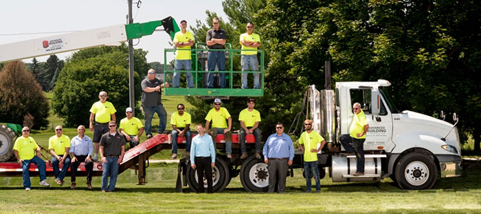 Team Members giving Pose for Photo on a Truck